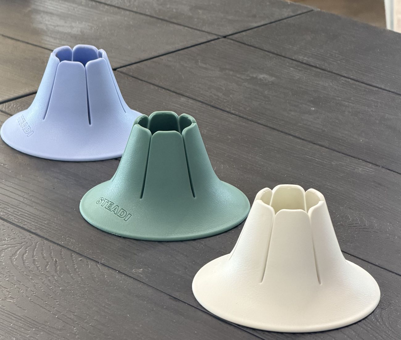 Three Steadis in sky, sage and white standing on a table.